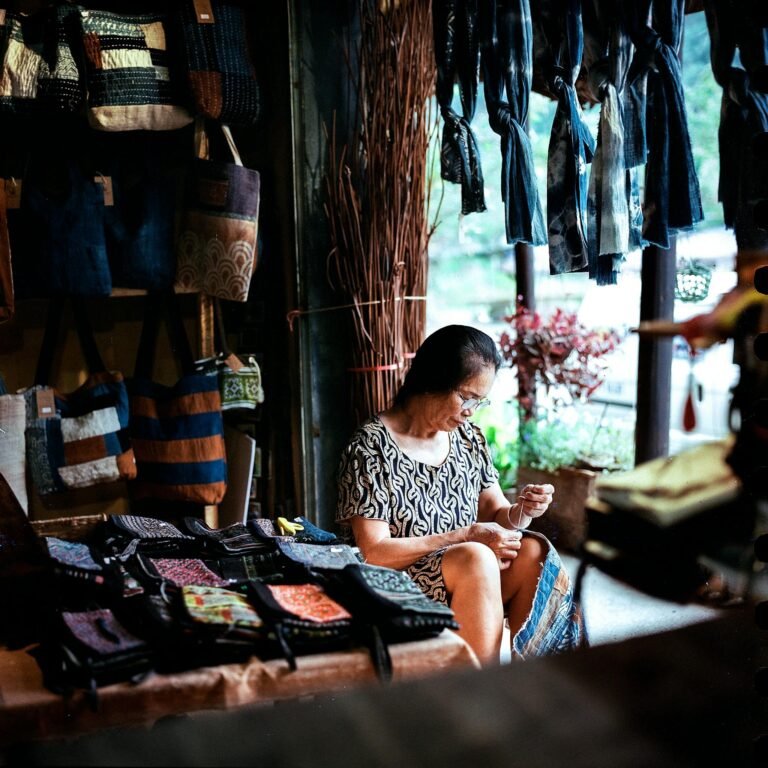 Elderly Woman Sitting and Sewing at Store