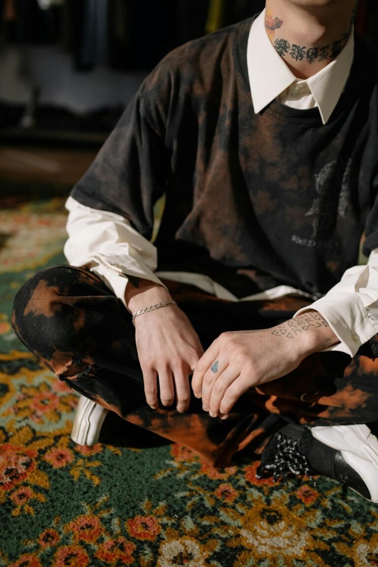 Man in Black Long Sleeve Shirt and White Pants Sitting on Brown Wooden Chair